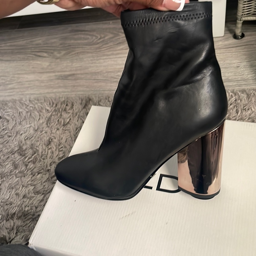 Black leather booties with rose gold heel.